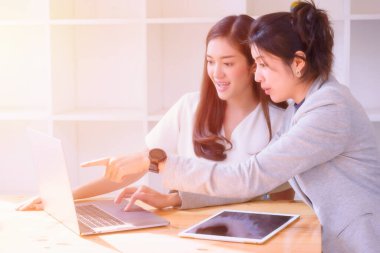 İki genç kız masadaki dizüstü bilgisayarla çalışmaktan zevk alıyor, yön ve ilham arıyorlar..