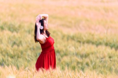 Güzel kız buğday tarlasında doğanın tadını çıkarıyor. Özgür Mutlu Kadın