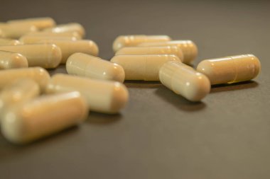 Jelatin kapsül ilaç ile tablo arasında dağılmış.