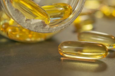 Jelatin kapsül ilaç ile tablo arasında dağılmış.