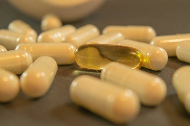 Jelatin kapsül ilaç ile tablo arasında dağılmış.