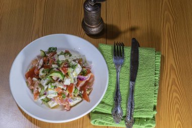 Çatal bıçak takımı ile bir tabakta sebze salatası.