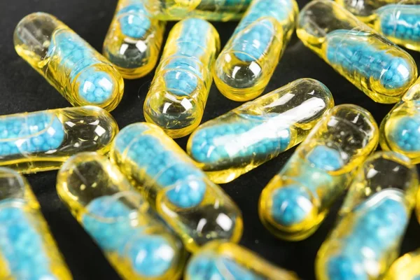 Gelatin capsules with the medicine are scattered across the table.