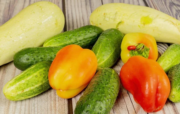 Färska gurkor, zucchini och paprika på ett träbord. Höstskörden Thanksgiving Day. — Stockfoto