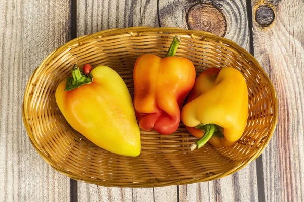 Sweet pepper in a wicker basket on a wooden table. Autumn harvest thanksgiving Day Stock Picture
