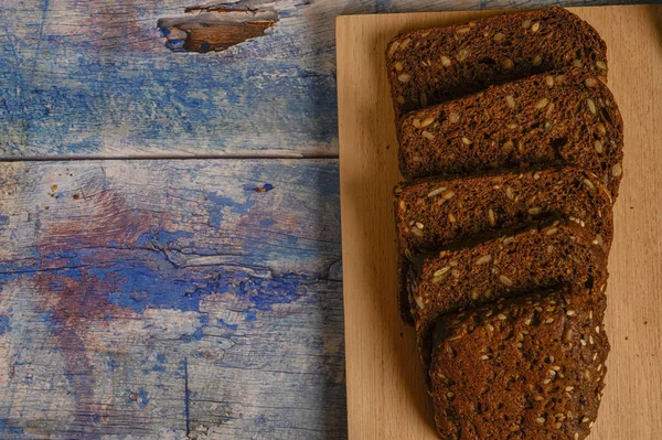 Нарезанный зерновой хлеб на деревянной доске. Обед в деревенском стиле . — стоковое фото