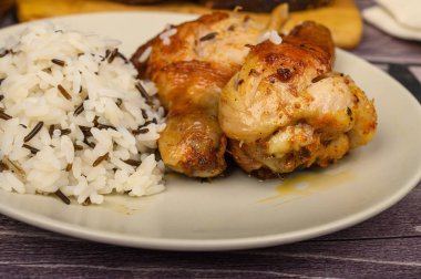 Bir kazanda kızartılmış baharat ile Tavuk bacakları, pirinç ile bir tabaktabaktabakta servis