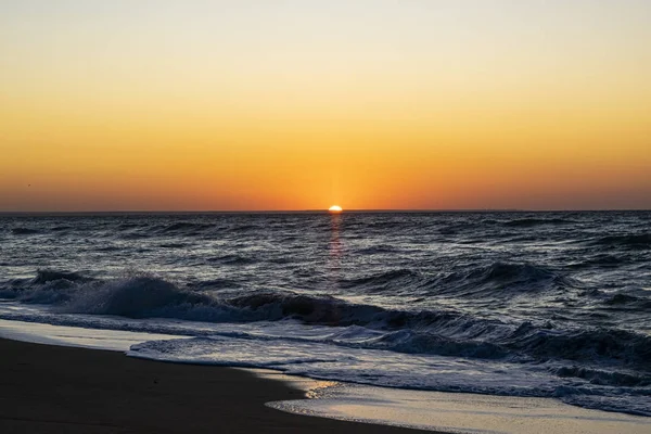 Sonnenaufgang über dem schwarzen Meer, Wellen am Sandstrand. — Stockfoto