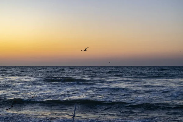 Sonnenaufgang über dem schwarzen Meer, Wellen am Sandstrand. — Stockfoto