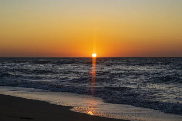 Sonnenaufgang über dem schwarzen Meer, Wellen am Sandstrand. — Stockfoto