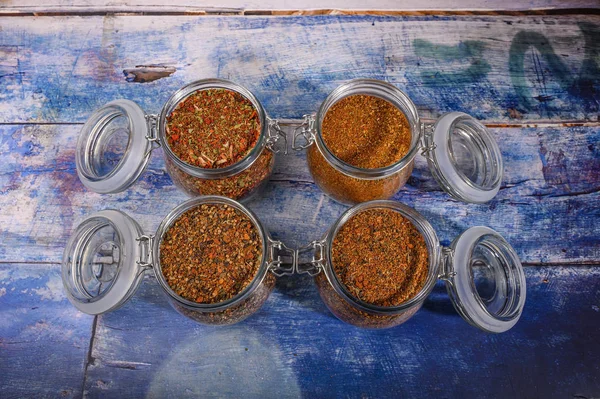 Fragrant spices in a glass jar with a lid and a metal lock on a wooden table. — Stock Photo, Image
