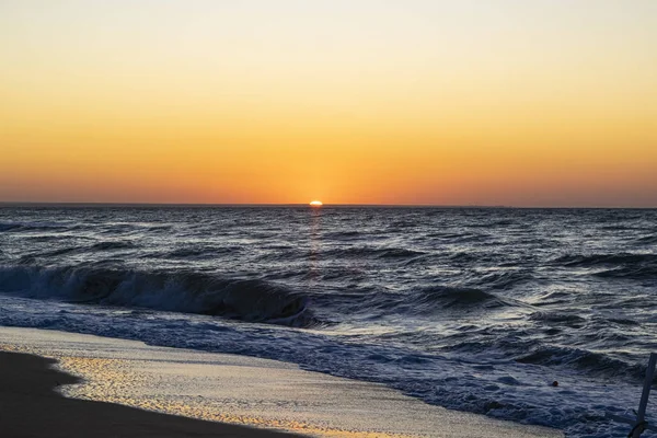 Sonnenaufgang über dem schwarzen Meer, Wellen am Sandstrand. — Stockfoto