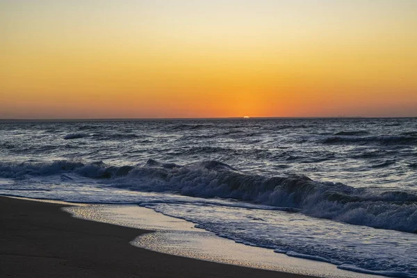 Sonnenaufgang über dem schwarzen Meer, Wellen am Sandstrand. — Stockfoto