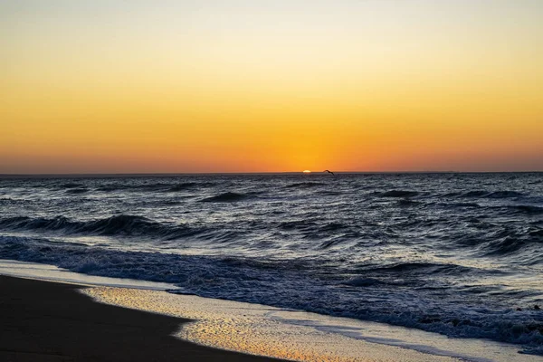 Sonnenaufgang über dem schwarzen Meer, Wellen am Sandstrand. — Stockfoto