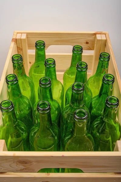 Empty wine bottles in a wooden box on the table. Home winemaking.