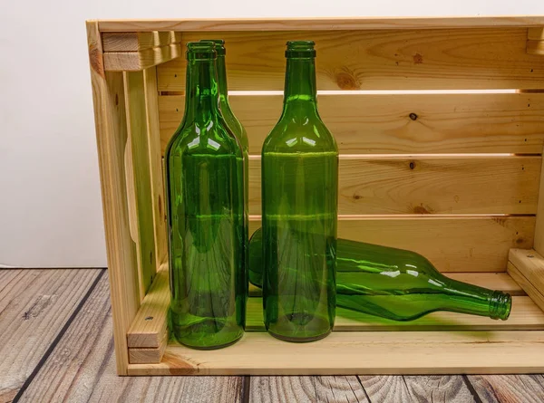 Empty wine bottles in a wooden box on the table. Home winemaking. — Stock Photo, Image