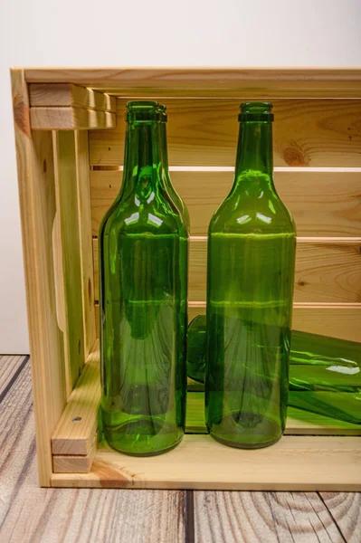 Botol anggur kosong dalam kotak kayu di atas meja. Pembuatan anggur di rumah . — Stok Foto