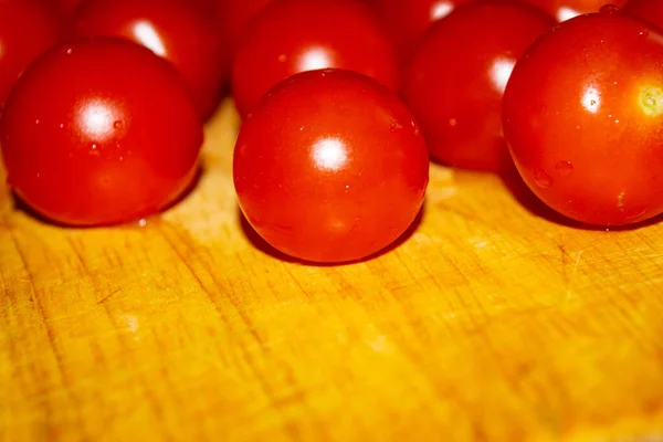 Small red cherry tomatoes on a wooden Board. Close up