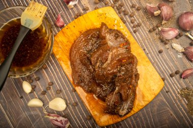 Kesme tahtasında marine edilmiş et, sarımsak, baharat, baharat. Kapat.