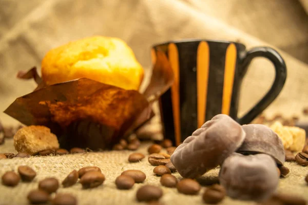 Frischer Cupcake Kaffeebecher Pralinen Und Kaffeebohnen Auf Einem Selbstgesponnenen Stoff — Stockfoto