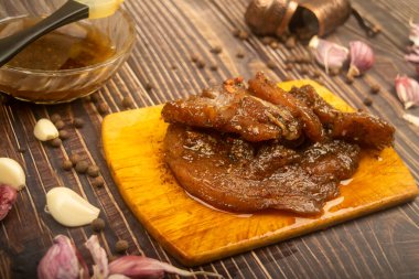 Kesme tahtasında marine edilmiş et, sarımsak, baharat, baharat. Kapat..