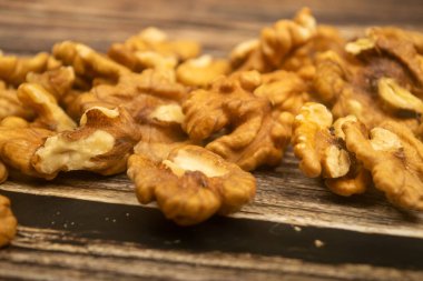 Ahşap masaya saçılmış cevizler. Sağlıklı beslenme. Fitness diyeti. Kapat.