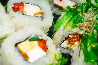 Balık, peynir ve yeşil yosunlu rulo. Geleneksel bir Japon yemeği. Kapat.