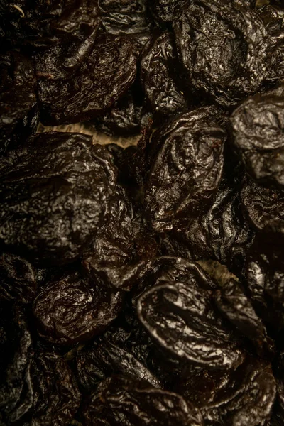 Dried prunes in bulk. Surface texture. Close up