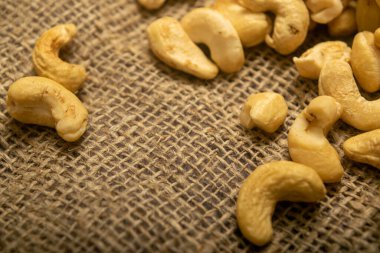 Çuval bezinde kabataslak desenli kaju fıstığı yığını. Kapat.