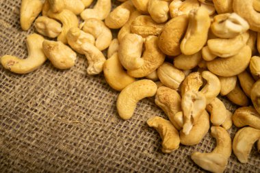 Çuval bezinde kabataslak desenli kaju fıstığı yığını. Kapat.