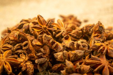 Çuval bezinin arka planında kabataslak desenli bir yıldız anason yığını. Kapat.