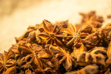 Çuval bezinin arka planında kabataslak desenli bir yıldız anason yığını. Kapat.