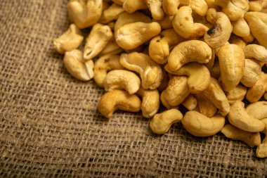 Çuval bezinde kabataslak desenli kaju fıstığı yığını. Kapat.