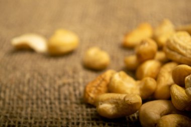 Çuval bezinde kabataslak desenli kaju fıstığı yığını. Kapat.