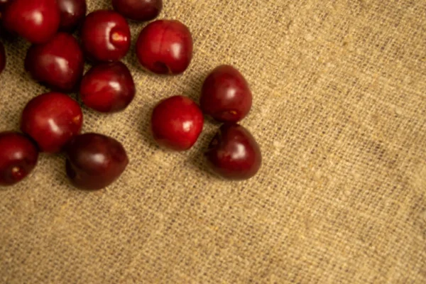 Ripe Juicy Cherries Scattered Homespun Fabric Rough Texture Close — Stock Photo, Image