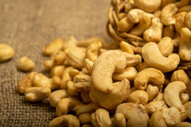 Çuval bezinde kabataslak desenli kaju fıstığı yığını. Kapat.