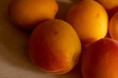 Olgun sulu kayısılar yüzeyin dokusunu kaplar. Kapat.