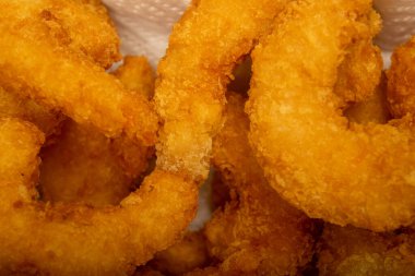 Hasır sepetteki beyaz kağıt peçetede hamurda kızartılmış Atlantik karidesleri. Kapat.