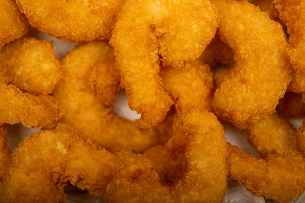 Hasır sepetteki beyaz kağıt peçetede hamurda kızartılmış Atlantik karidesleri. Kapat.