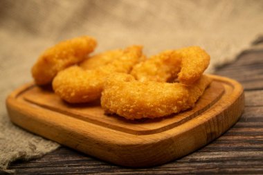 Tahta servis tahtasının üzerinde kızartılmış Atlantik karidesleri. Kapat.