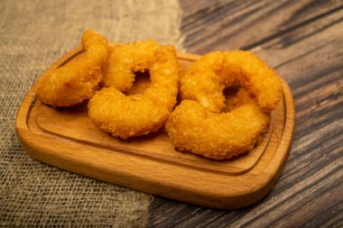 Tahta servis tahtasının üzerinde kızartılmış Atlantik karidesleri. Kapat.