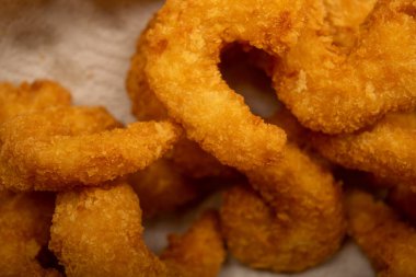 Hasır sepetteki beyaz kağıt peçetede hamurda kızartılmış Atlantik karidesleri. Kapat.