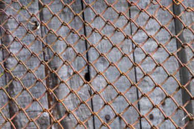 Pasla kaplı eski metal örgü ve arkada eski ahşap bir duvar, yakın plan, seçici odak