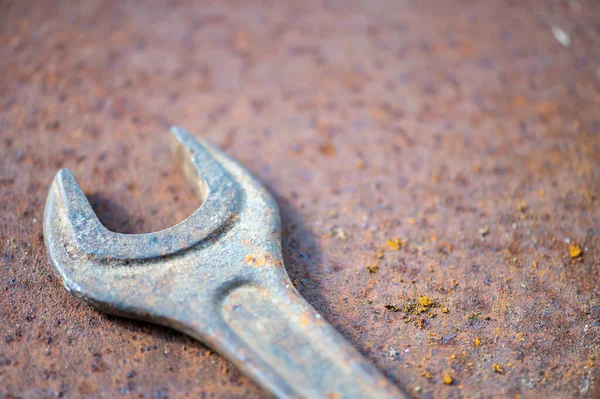 An old spanner on a rusty sheet of metal, close-up, selective focus