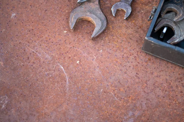 Old wrenches on a rusty sheet of metal, close-up, selective focus
