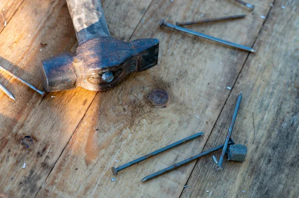 Old vintage hammer and nails on a wooden background, close-up, selective focus