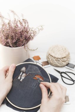 El yapımı nakış yapan bir kız. Genç kız siyah maddeye bir desen nakışlıyor. İğne işi. Dikiş aracı.