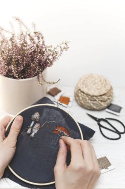 El yapımı nakış yapan bir kız. Genç kız siyah maddeye bir desen nakışlıyor. İğne işi. Dikiş aracı.