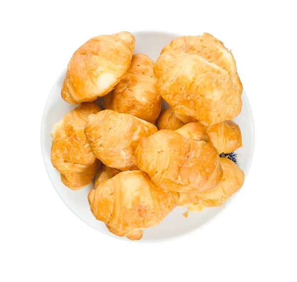 Croissante într-o placă rotundă izolată pe fundal alb — Fotografie, imagine de stoc