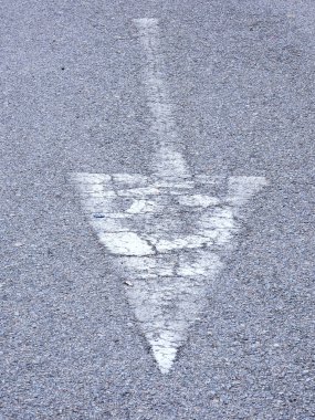 sürücülere ne yapmaları gerektiğini veya izlemeleri gereken yönü göstermek için gri yolda beyaza boyanmış tabela